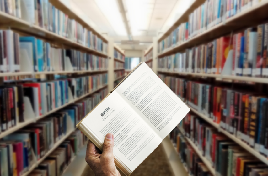 Hand holding book in library