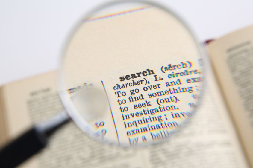 Magnifying glass hovering over word "search"